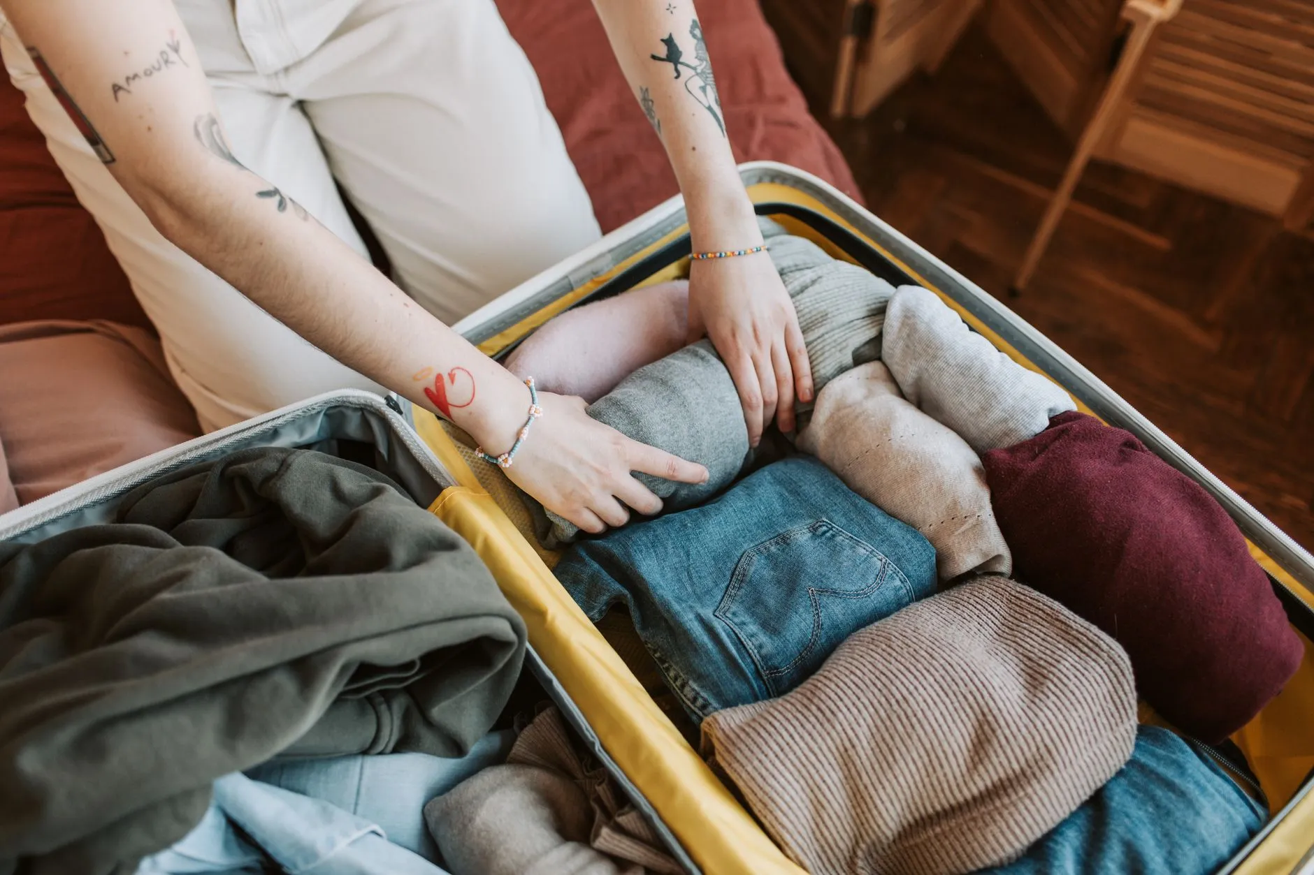Clothes being packed into a suitcase with packing cubes